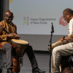 Two Black men performing African drumming