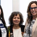 Three women standing together and smiling