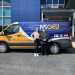 A United Way Halifax employee and an NSGEU employee standing in front of NSGEU's branded work van.