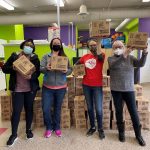 Two United Way staff members standing with two donors who gave a large amount of menstrual products in support of United Way Halifax