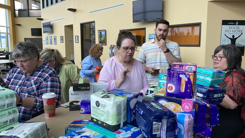 Volunteers count packages of menstrual products