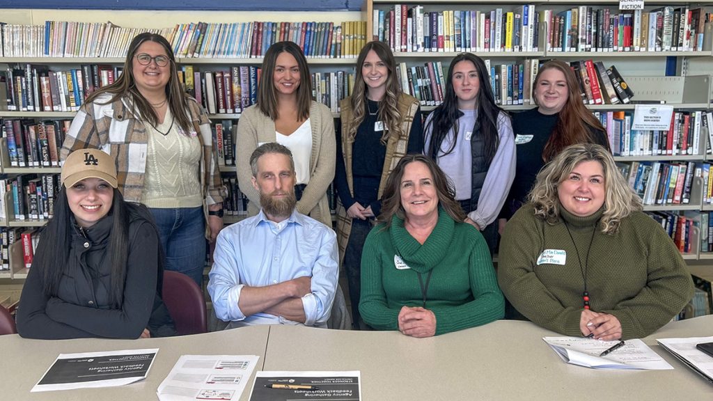 A group of people in front of stacks of books